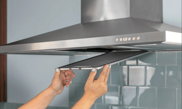 thợ Xuân Dũng đang lắp quạt hút mùi bếp